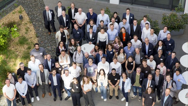 Gruppenfoto von den Teilnehmenden des HIPOBAT-Projekttreffens, die vor einem modernen Gebäude sstehend in die Kamera blicken.